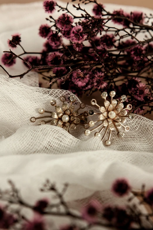 a bunch of flowers sitting on top of a white cloth, a digital rendering, by artist, unsplash, baroque, cute earrings. highly detailed, pins of light, mid 1 9 th century, fireworks