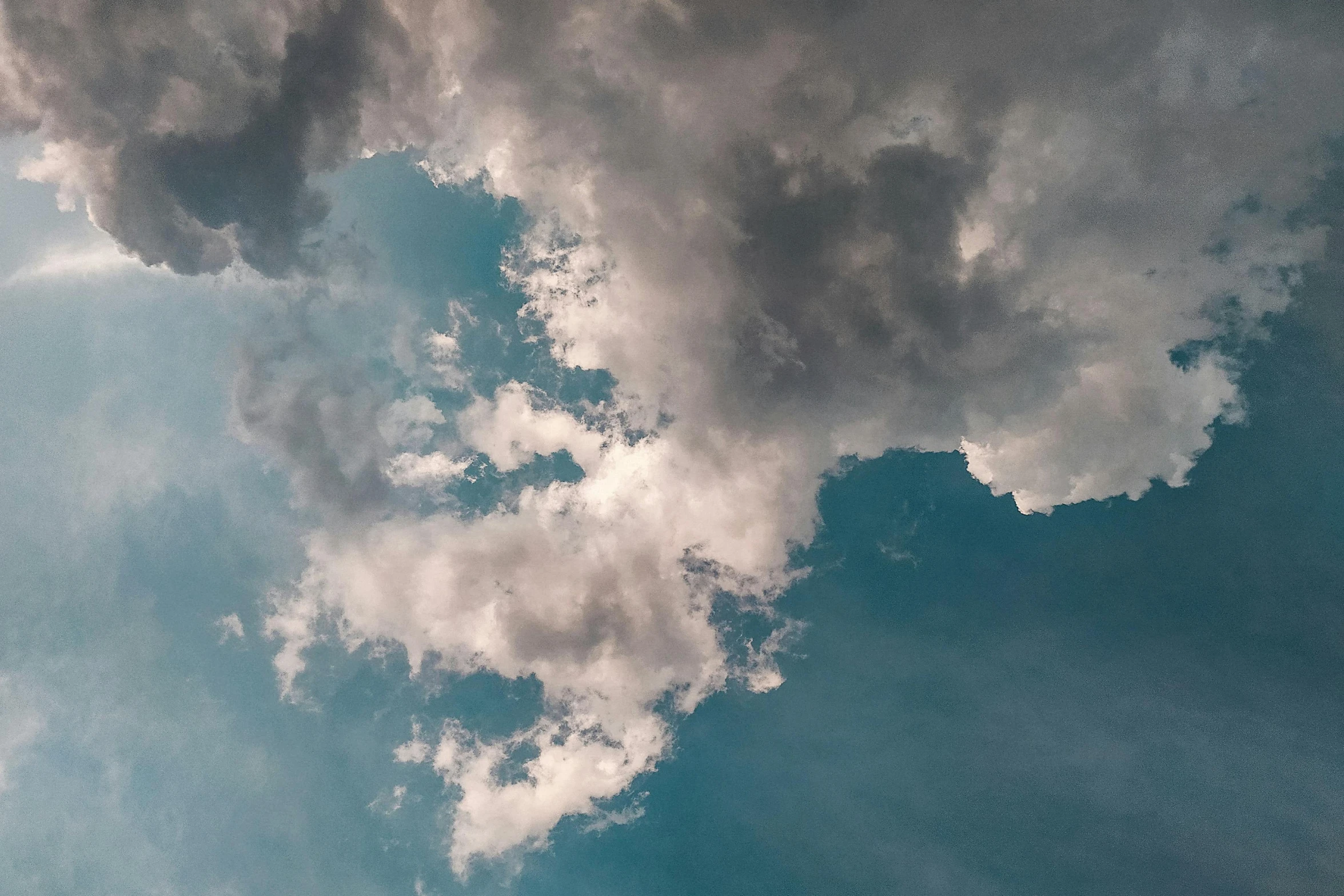 a plane flying through a cloudy blue sky, by Carey Morris, pexels contest winner, minimalism, interstellar stormy bright sky, looking upwards, late afternoon lighting, looking up onto the sky