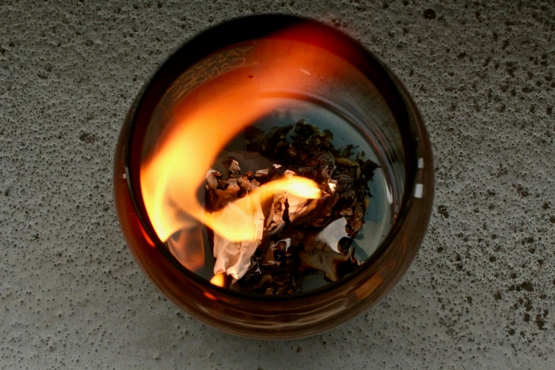a close up of a fire in a glass, inspired by Kaigetsudō Ando, torches in ground, copper patina, high angle shot, exterior shot