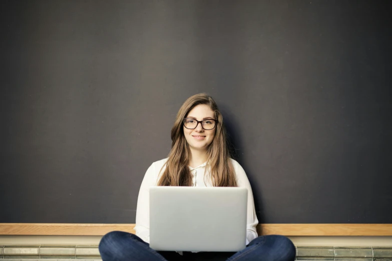 a woman sitting on the floor with a laptop, by Carey Morris, pixabay, blackboard in background, portrait of white teenage girl, background image, 15081959 21121991 01012000 4k