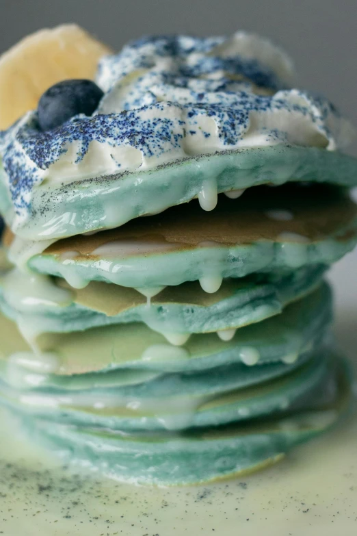 a stack of pancakes sitting on top of a white plate, inspired by Joris van der Haagen, tones of blue and green, frosted, intricate pasta waves, close-up