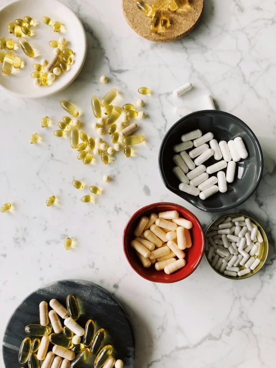 a table topped with lots of different types of pills, by Arabella Rankin, unsplash, shot for pottery magazine, jovana rikalo, dwell, on kitchen table