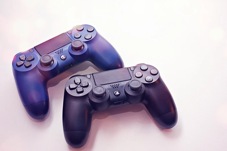 a couple of video game controllers sitting next to each other, by Carey Morris, pexels, computer art, on a pale background, purple and black, shot on sony a 7, blue or red