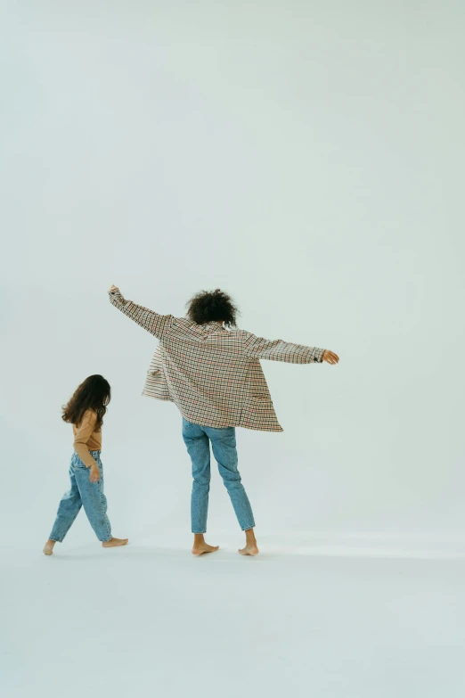 a woman standing next to a little girl on a white background, by Carey Morris, pexels, minimalism, she is dancing. realistic, denim, muted colors. ue 5, dwell