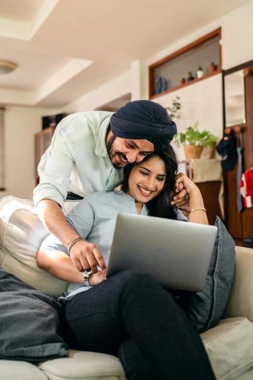 a man and woman sitting on a couch looking at a laptop, pexels contest winner, india, embracing, thumbnail, high resolution image