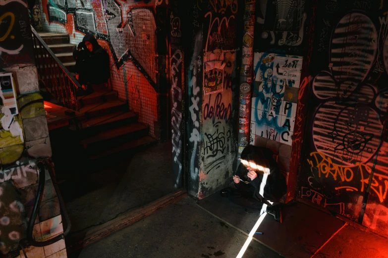 a person riding a scooter in a room with graffiti on the walls, a photo, inspired by Elsa Bleda, pexels contest winner, a 1980s goth nightclub in soho, kneeling, light from above, looking for clues