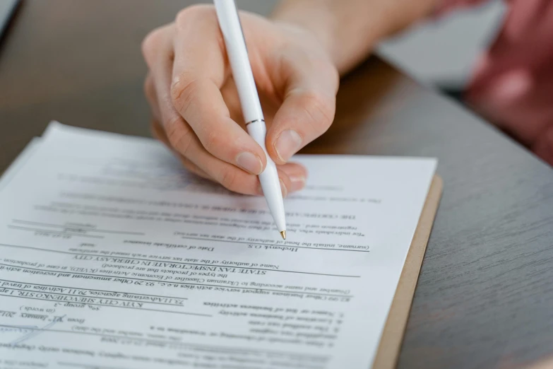 a person writing on a piece of paper with a pen, serving suggestion, background image, thumbnail