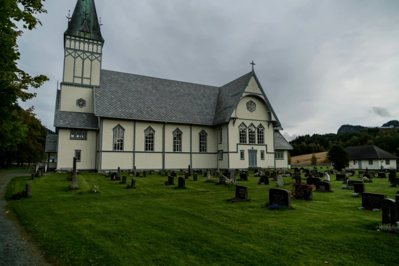 a church sitting on top of a lush green field, in a graveyard, bjørn, slight overcast lighting, slate