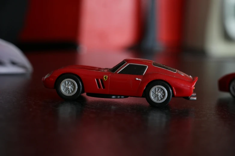 two toy cars sitting next to each other on a table, by Kev Walker, pexels contest winner, ferrari, side profile view, micro pov, 2 4 0 p footage