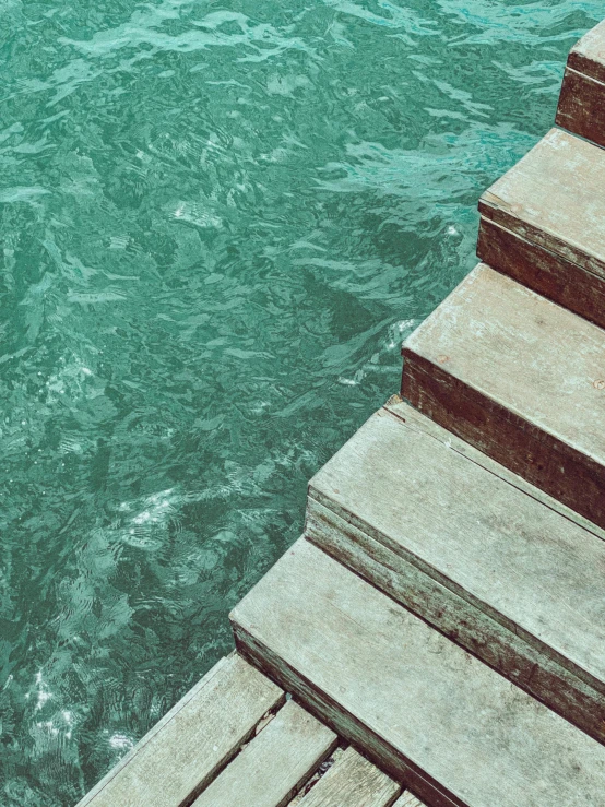 a wooden dock next to a body of water, an album cover, inspired by Elsa Bleda, trending on unsplash, modernism, old stone steps, floating. greenish blue, vertical wallpaper, highly turbulent