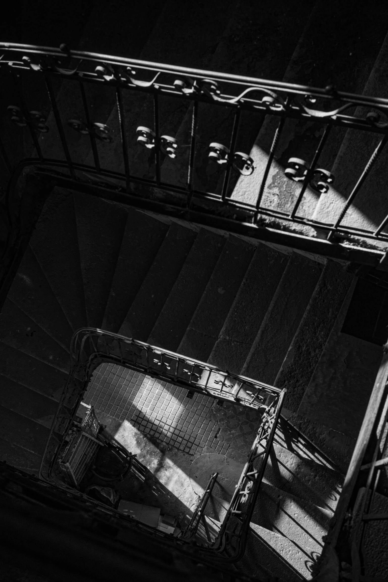 a black and white photo of a staircase, inspired by Brassaï, unsplash contest winner, baroque, square, high view, dark aesthetic, early morning light