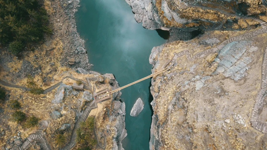 an aerial view of a bridge over a river, by Jessie Algie, pexels contest winner, hurufiyya, uttarakhand, highly detailed rock structures, thumbnail, helicopter view