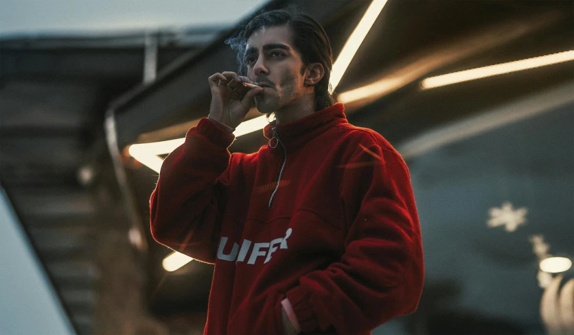 a man in a red jacket talking on a cell phone, an album cover, inspired by Elsa Bleda, unsplash contest winner, lyco art, puffs of smoke, wearing a track suit, portrait shot 8 k, yzy gap