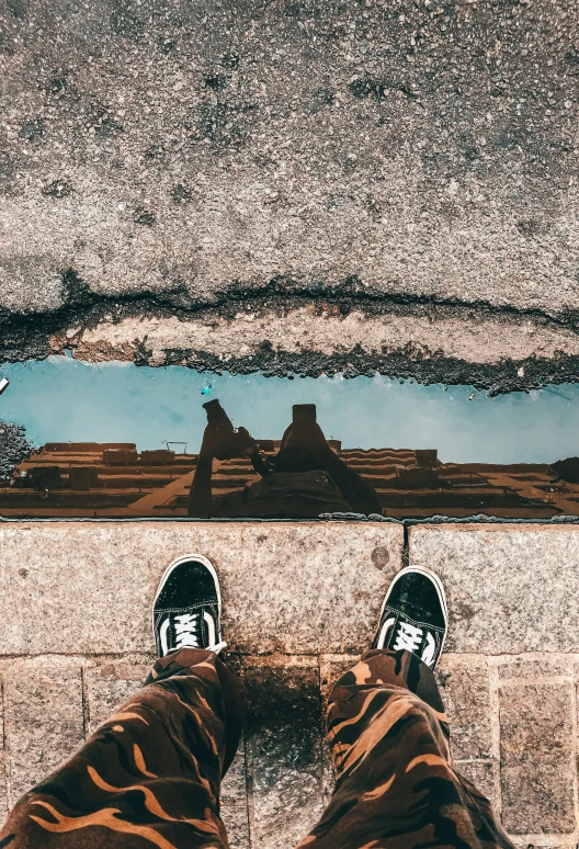 a person standing in front of a puddle of water, a picture, unsplash contest winner, street art, looking down on the view, sitting down casually, waterline refractions, instagram story