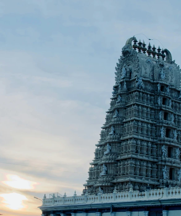 a tall building sitting on top of a lush green field, a marble sculpture, unsplash contest winner, indian temple, draped in shiny gold and silver, evening at dusk, closeup - view