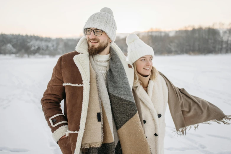 a man and a woman standing in the snow, trending on pexels, straw hat and overcoat, browns and whites, hygge, thumbnail