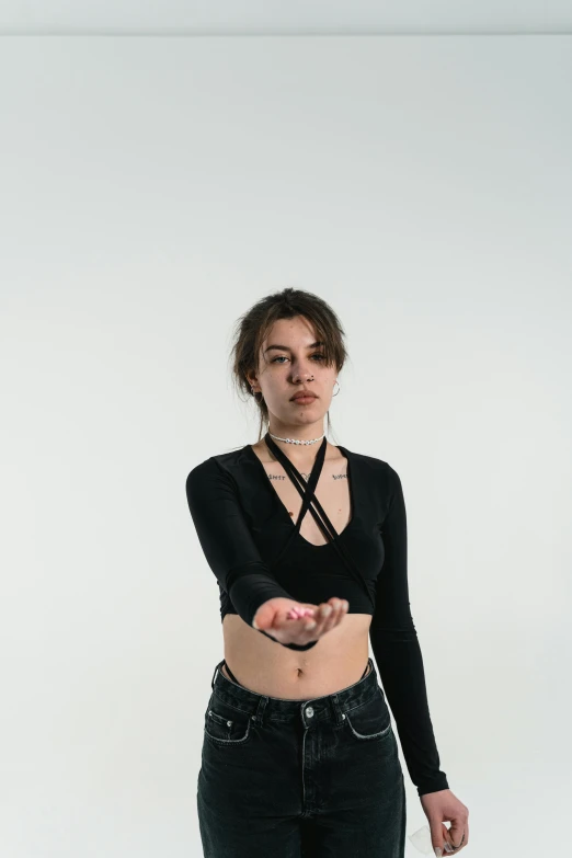 a woman in a black top and jeans posing for a picture, an album cover, inspired by Elsa Bleda, trending on pexels, antipodeans, bandage taped fists, studio portrait photo, looking up, wearing choker