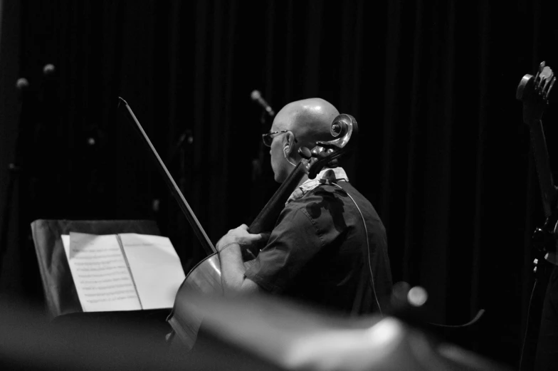 a black and white photo of a man playing a cello, by David Palumbo, concert, marin kitagawa, double bass, uploaded