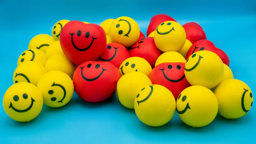 a pile of yellow and red balls with smiley faces on them, a picture, by Gavin Nolan, pexels, toyism, optimistic smile, 😃😀😄☺🙃😉😗, serene smile, red and teal and yellow