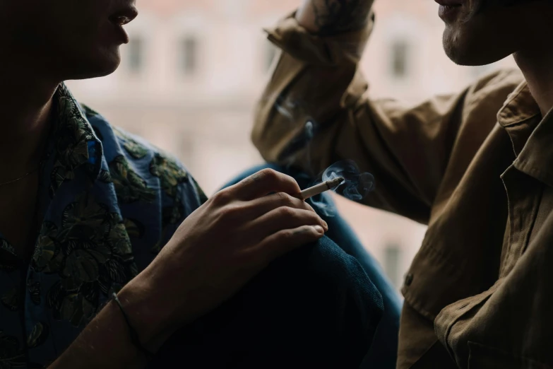 a couple of men sitting next to each other, by Emma Andijewska, trending on pexels, renaissance, hand holding cigarette, avatar image, lesbian, servando lupini