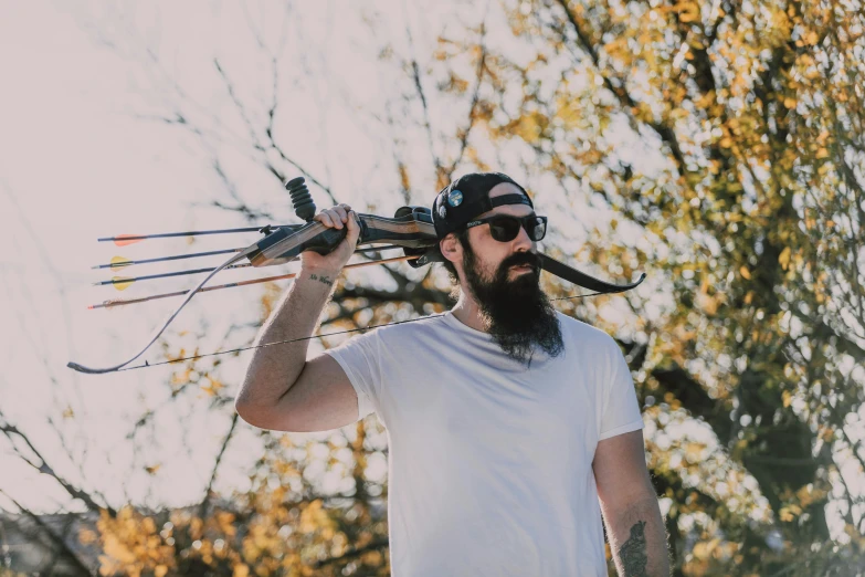 a man with a beard and a pair of skis on his head, pexels contest winner, realism, woman holding recurve bow, hipster dad, nature outside, hold mechanical bow and arrow