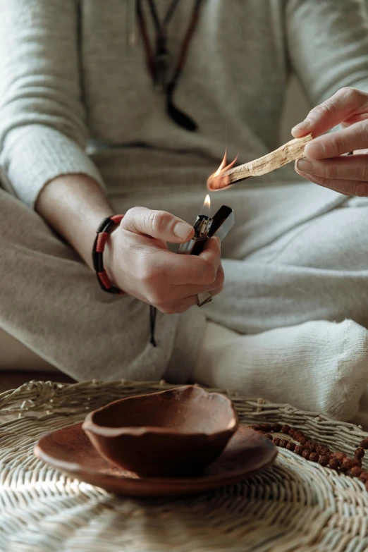 a woman lighting a match with a matchstick, trending on pexels, smoking a bowl of hash together, clay amulets, hemp, tie-dye