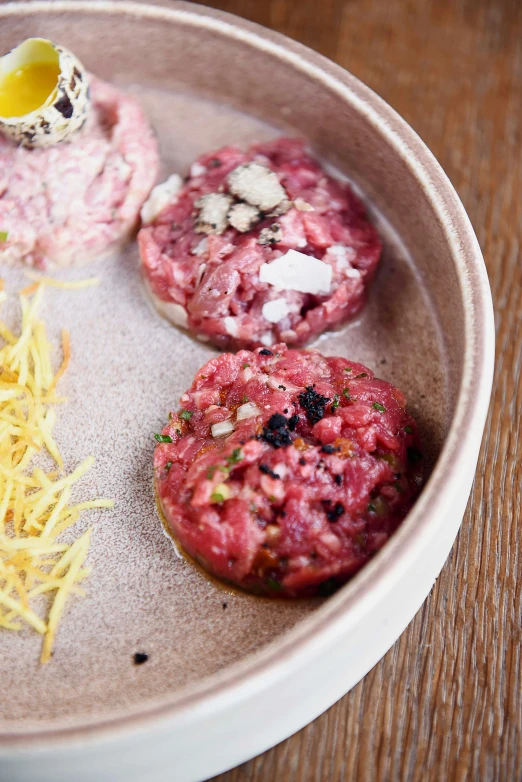 a close up of a plate of food on a table, ground meat, 3 heads, dwell, striking colour