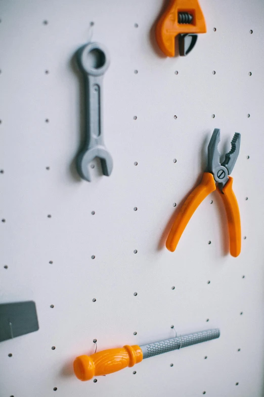 a bunch of tools that are on a wall, inspired by Rube Goldberg, pexels, orange grey white, 3d printed, polka dot, detail shot