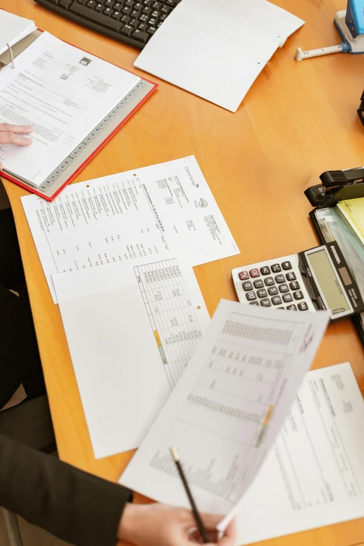 a woman sitting at a desk with papers and a calculator, by Matt Cavotta, trending on reddit, private press, top - down photo, selling insurance, 15081959 21121991 01012000 4k, instagram post