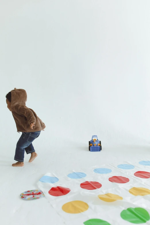 a young boy playing a game of hop hop hop hop hop hop hop hop hop hop hop hop hop hop hop hop hop hop hop hop hop, an album cover, by Shigeru Aoki, unsplash, brown red blue, only one robot kid on the ground, studio photoshoot, colored dots