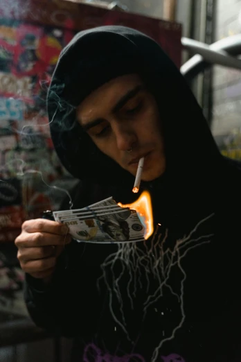a man in a black hoodie lighting a cigarette, an album cover, pexels contest winner, hyperrealism, low quality photo, ✨🕌🌙, hasan piker, robbery