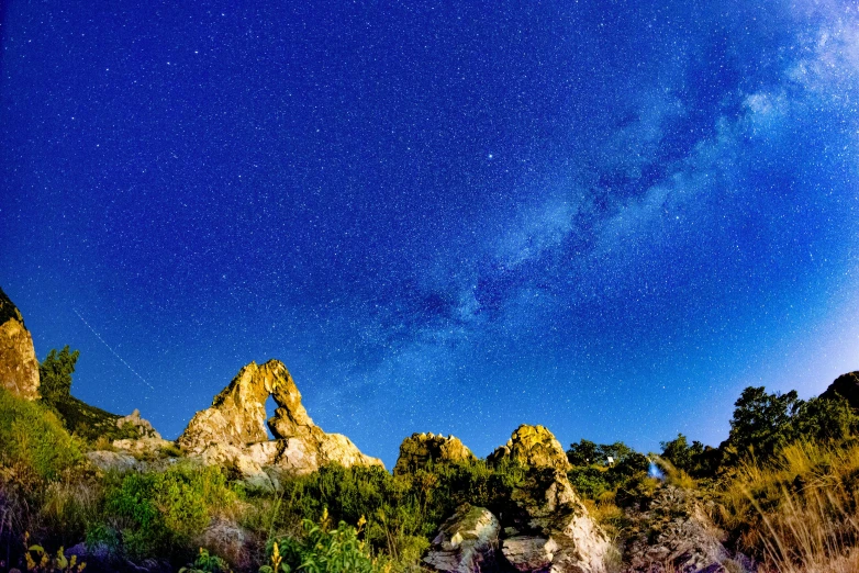 a man flying a kite on top of a lush green hillside, an album cover, unsplash, romanticism, night sky with many meteorites, cyprus, rock arches, thumbnail