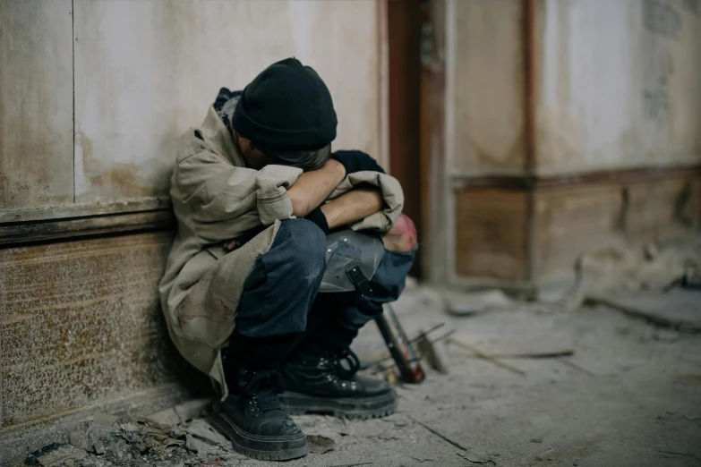 a man sitting on the side of a building, pexels contest winner, arte povera, hugging his knees, homeless, boy, 15081959 21121991 01012000 4k