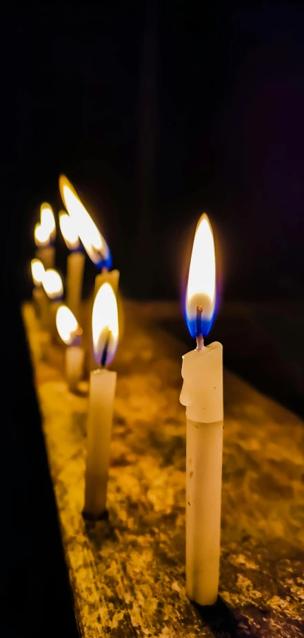 a row of lit candles sitting on top of a table, profile image, parce sepulto, uploaded, high quality photo