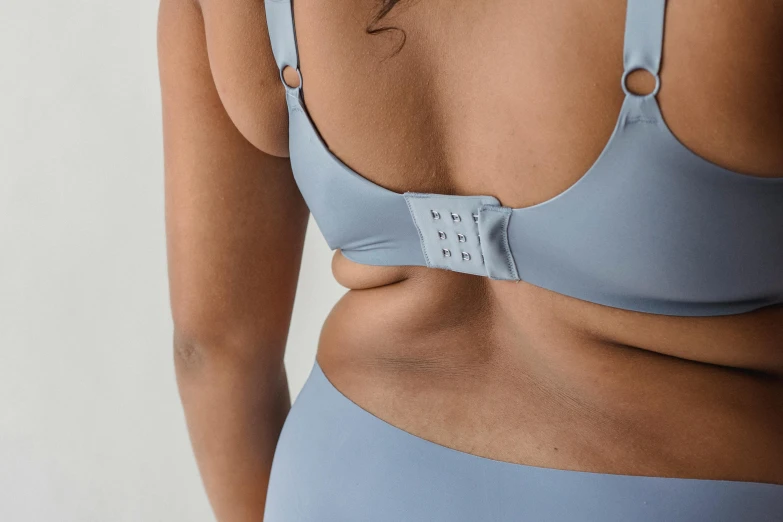 a close up of a person wearing a bra, blue gray, view(full body + zoomed out), silicone skin, center punched