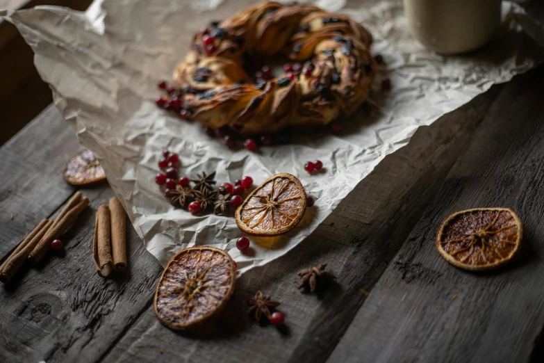 a pastry sitting on top of a piece of paper next to a cup of coffee, a still life, pexels contest winner, organic ornaments, rondel, spices, thumbnail