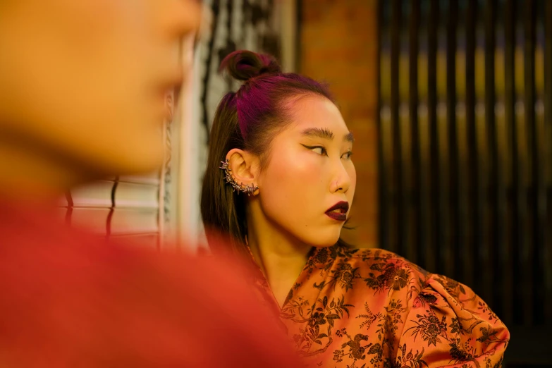 a woman looking at her reflection in a mirror, an album cover, inspired by Xia Chang, trending on pexels, wearing ornate earrings, at a fashion shoot, ethnicity : japanese, late evening