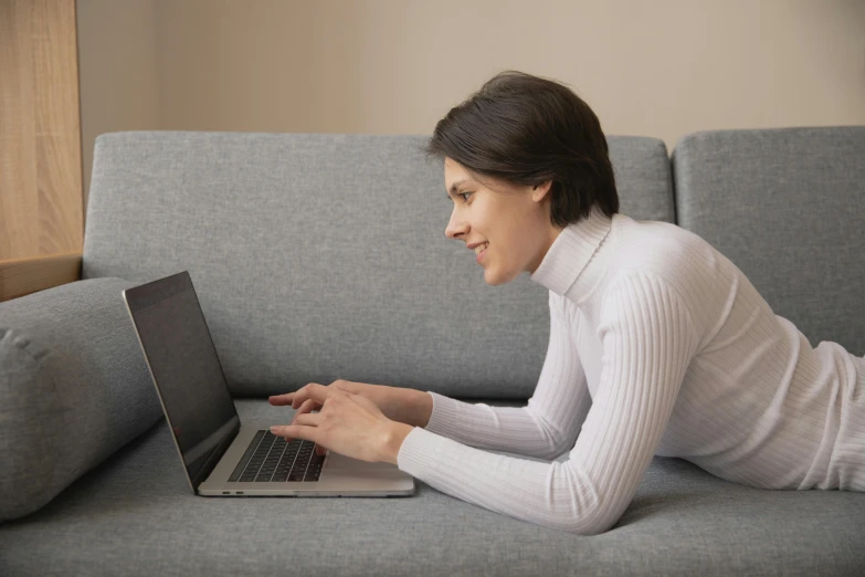 a woman laying on a couch using a laptop, trending on pexels, alexandria ocasio cortez, dylan kowalsk, computer game, plain background