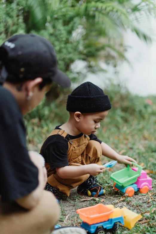 a man and a child playing with toys in the grass, pexels contest winner, streetwear, square, small in size, black