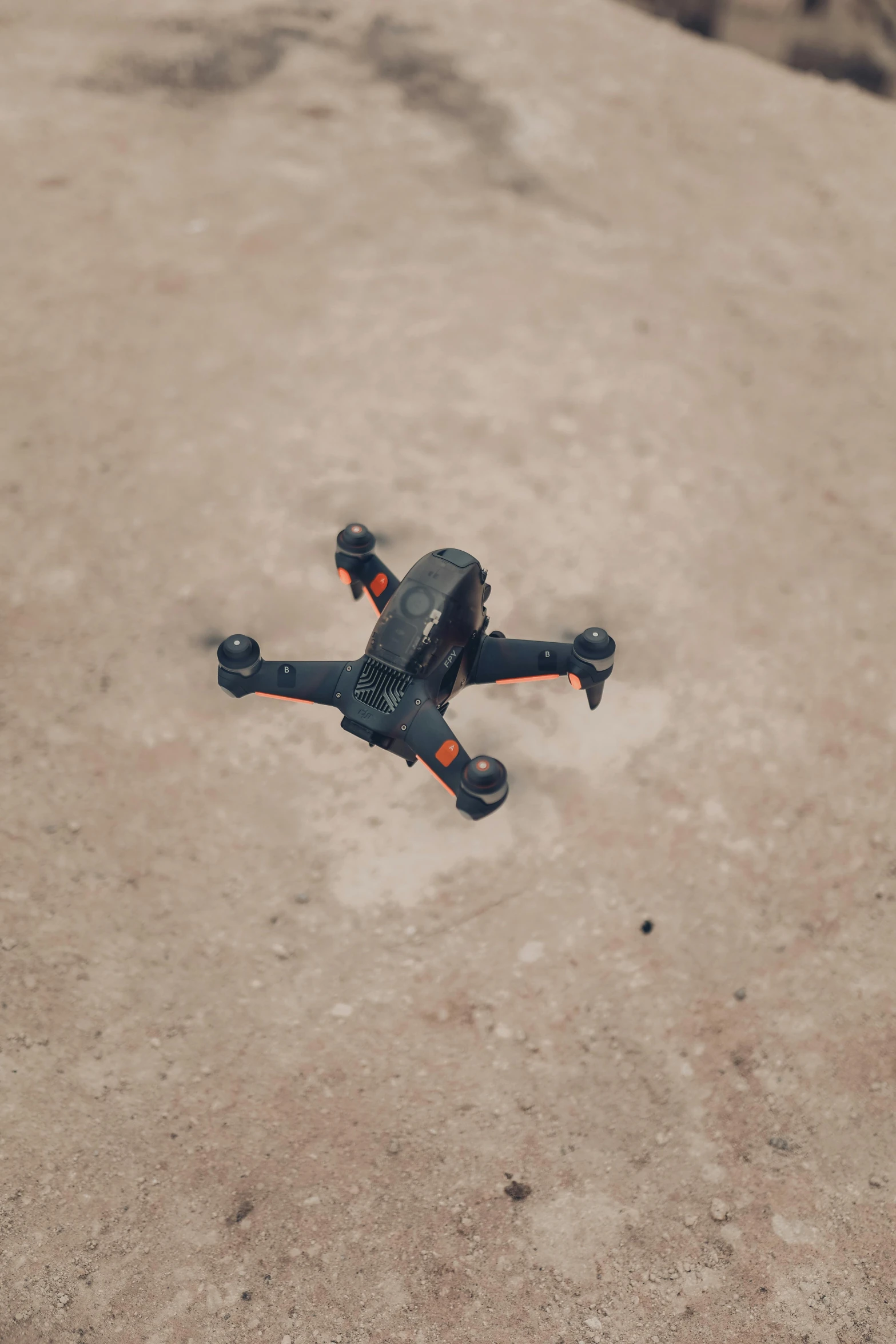 a small black drone sitting on top of a dirt field, pexels contest winner, figuration libre, on the concrete ground, slightly pixelated, crash, 2070s