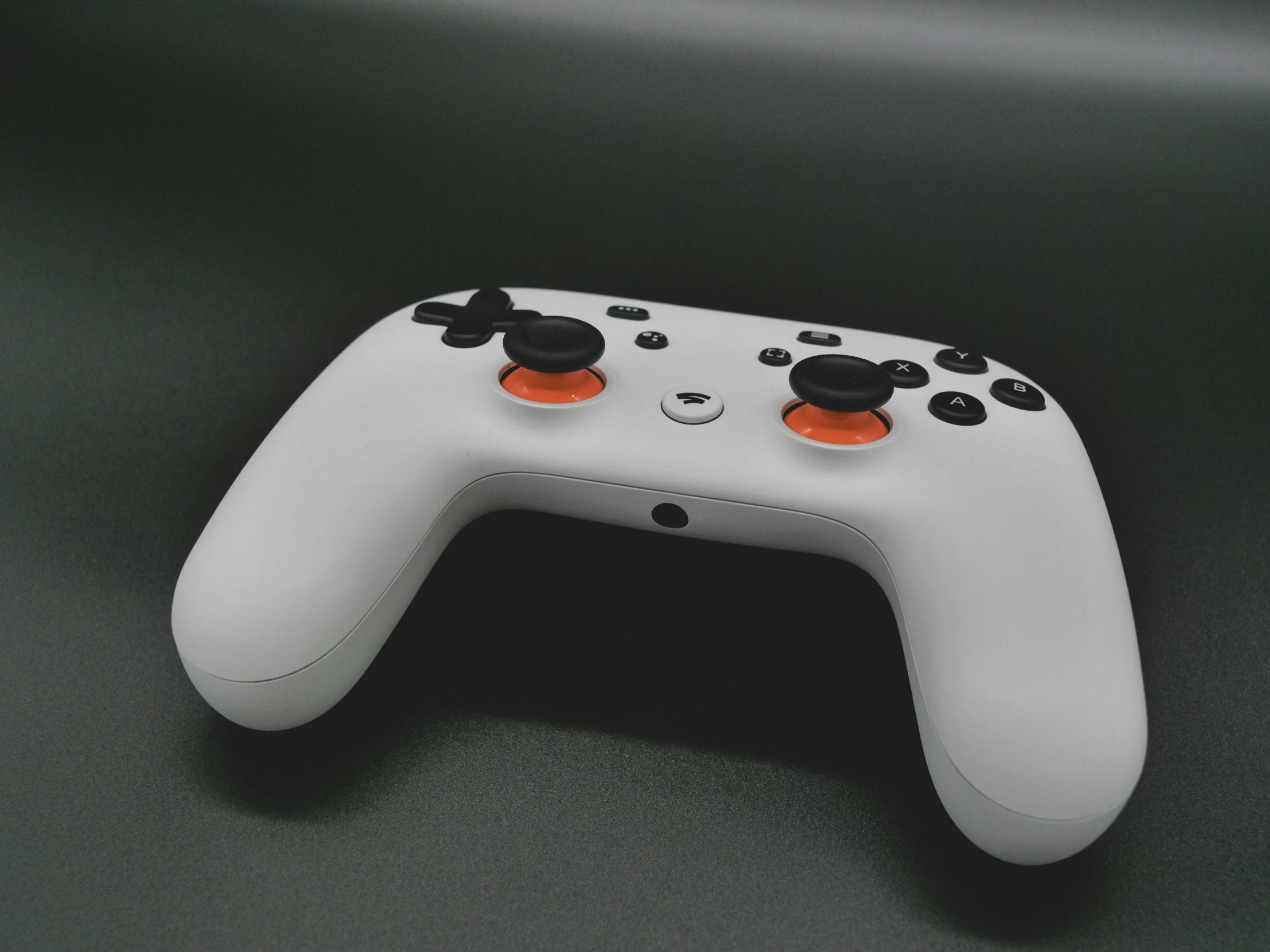 a close up of a controller on a table, an ambient occlusion render, by Carey Morris, unsplash, bauhaus, grey orange, google point of view, front cover of a new video game, on a gray background