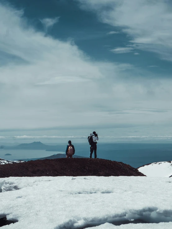 two people standing on top of a snow covered mountain, a photo, by Lucia Peka, happening, kahikatea, iconic scene, high quality image”, multiple stories