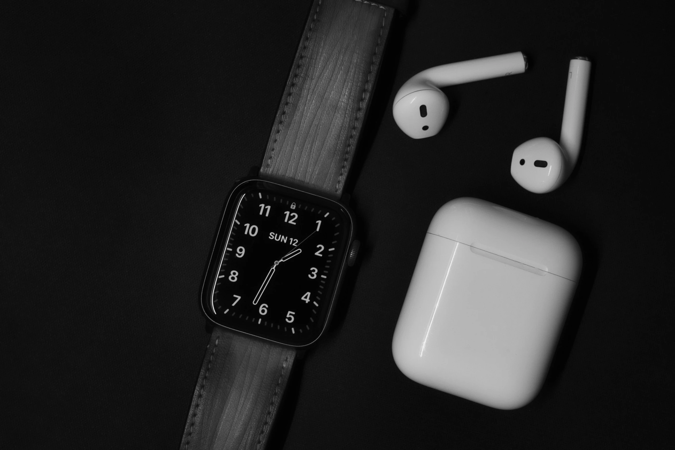 a black and white photo of an apple watch and airpods, a black and white photo, black ambient background, items and gadget, square, clock