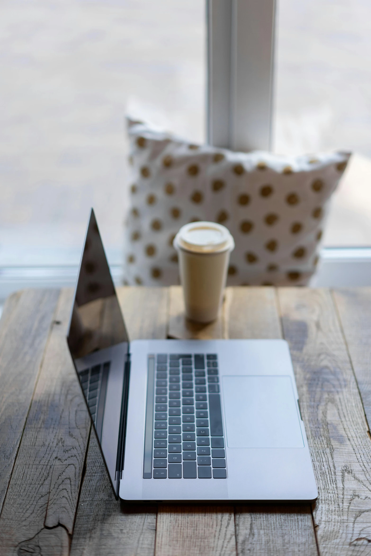 a laptop computer sitting on top of a wooden table, drinking a coffee, square, gold, window open