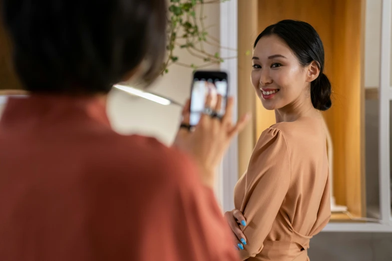 a woman taking a picture of herself in the mirror, inspired by helen huang, happening, close up to the screen, elegant smiling pose, giving an interview, product shot