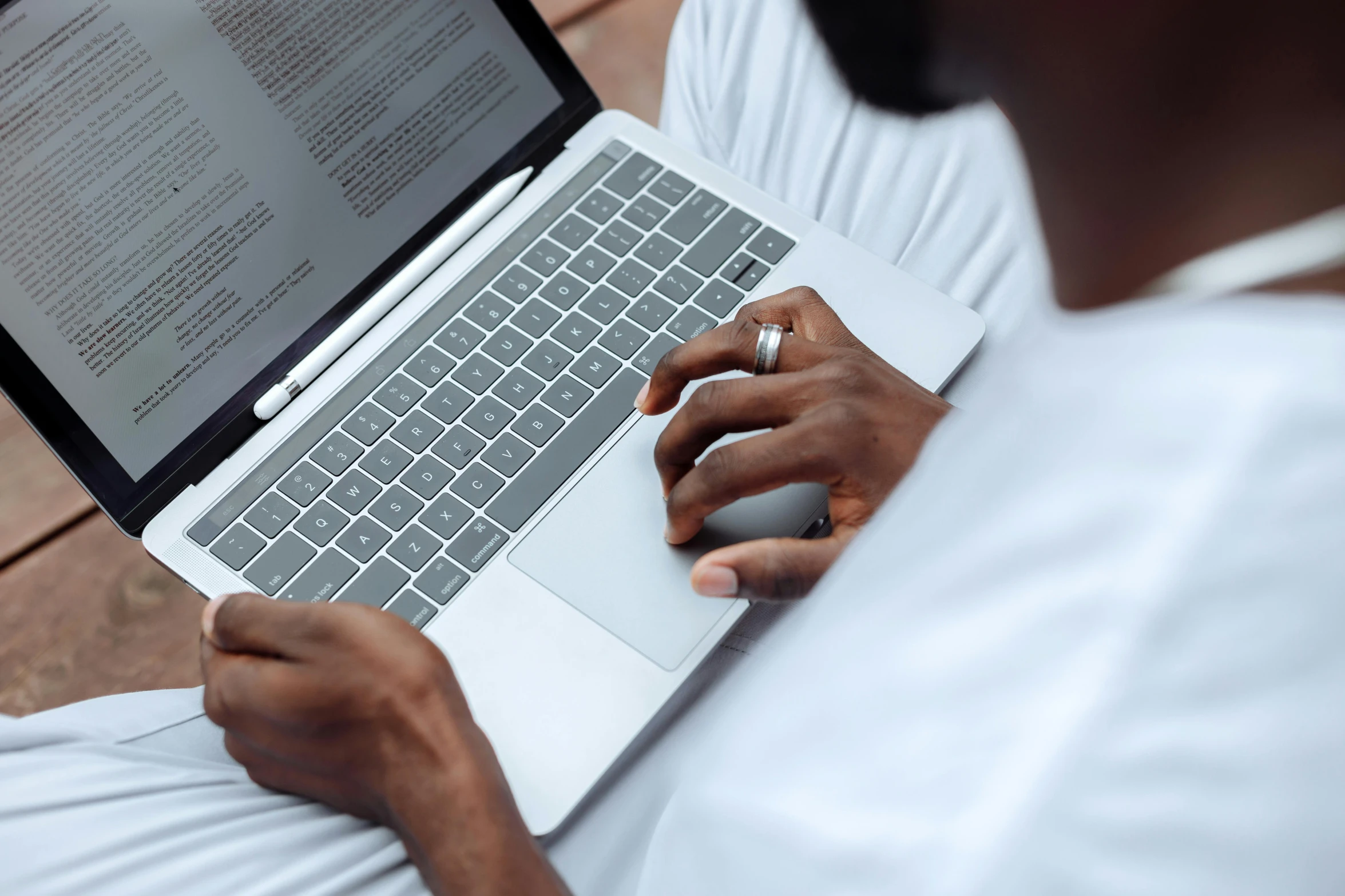 a man sitting on a bench using a laptop computer, a screenshot, by Carey Morris, pexels contest winner, someone sits in bed, afro tech, close up to the screen, writing a letter