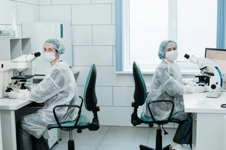 a couple of people that are sitting at a desk, clean medical environment, wearing hoods, dasha taran, profile image