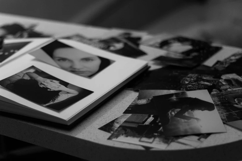 an open book sitting on top of a table, a black and white photo, process art, close - up shots of faces, 2 0 0 0's photo