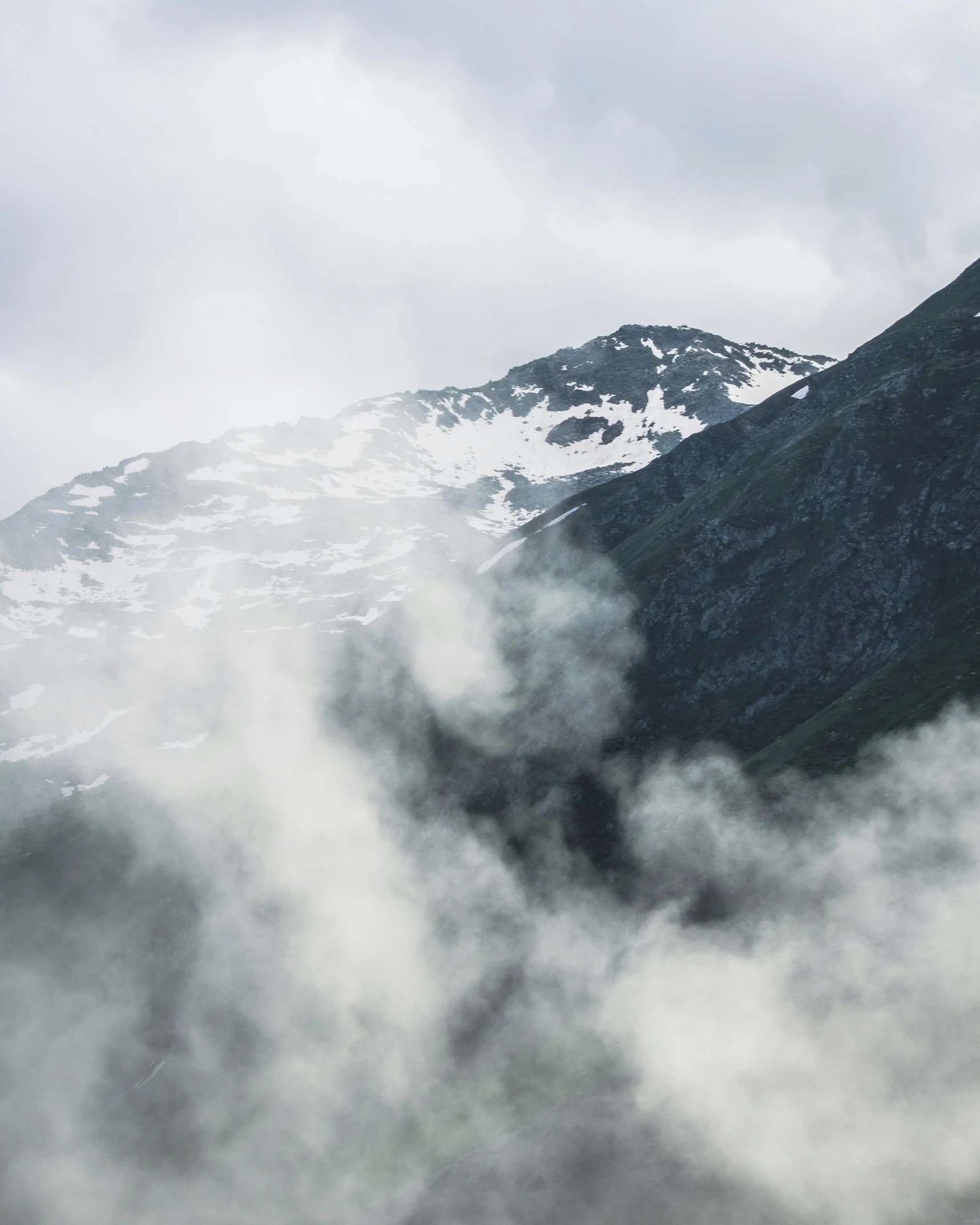 a plane flying over a mountain covered in snow, by Christen Dalsgaard, pexels contest winner, hurufiyya, smoke coming out of her mouth, moist foggy, norwegian, large mountain