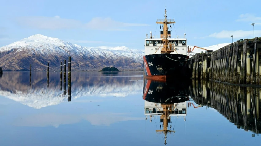 a large boat sitting on top of a body of water, inspired by Edwin Deakin, pexels contest winner, hurufiyya, lariennechan, reflection on the oil, new zealand, snowy fjord